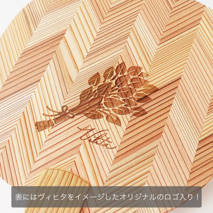 木製うちわの表面にレーザー刻印された、植物（ヴィヒタ）をモチーフにしたオリジナルロゴ
